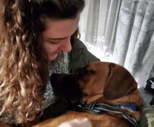 Young women cuddling her dog 